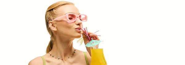 Young woman with stylish sunglasses sips a refreshing beverage, radiating joy and fashion. — Stock Photo