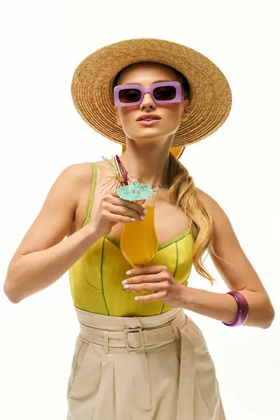 Mulher brilhantemente vestida saboreia uma bebida colorida enquanto irradia vibrações de verão sob céus ensolarados. — Fotografia de Stock