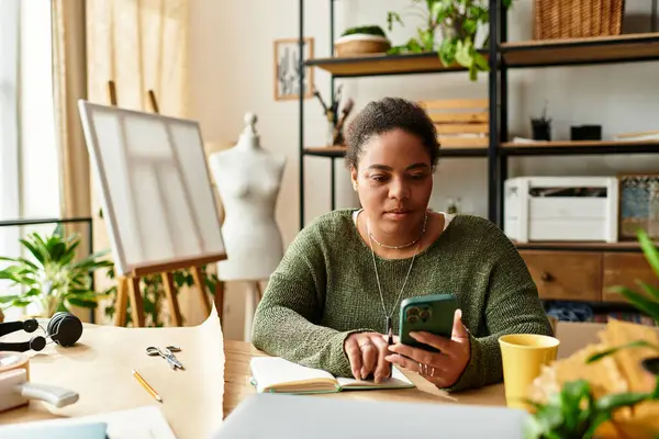 Una hermosa mujer se involucra con su teléfono, recogiendo inspiración en medio de herramientas de elaboración y plantas. - foto de stock
