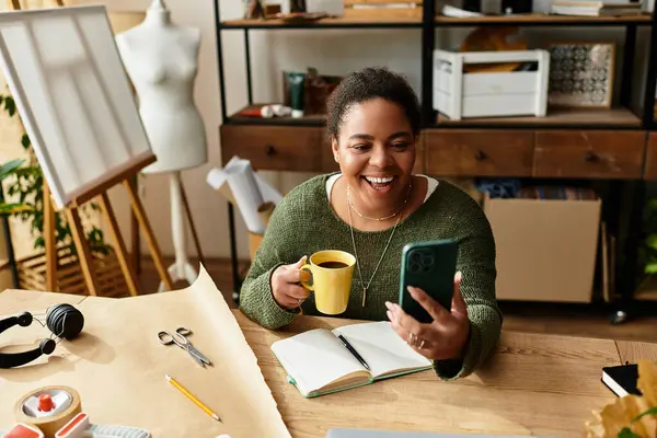 Uma mulher bonita gosta de café enquanto explora ideias de artesanato em um ambiente de oficina acolhedor. — Fotografia de Stock