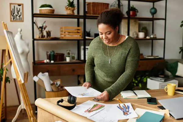 Une femme joyeuse explore ses créations dans un atelier vibrant. — Photo de stock