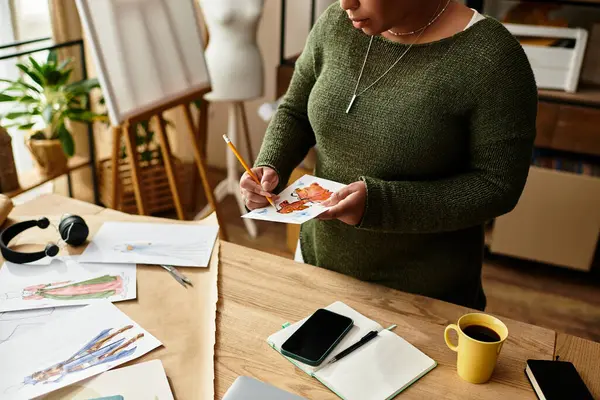A beautiful woman is deeply engaged in crafting while surrounded by various art pieces and supplies. — Stock Photo