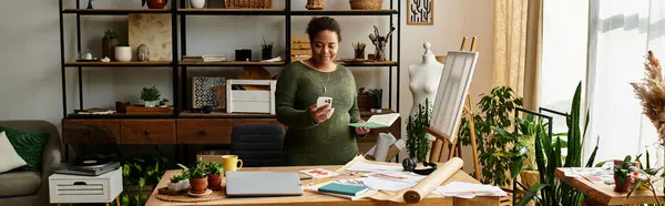 A lovely woman crafts happily in a vibrant workshop filled with materials and plants. — Stock Photo