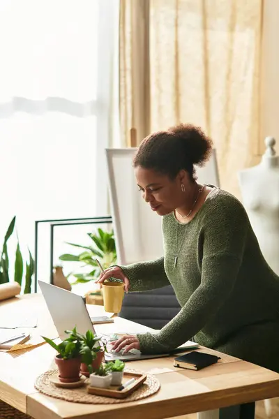 A lovely woman crafts while sipping a drink in a cozy workshop. — Stock Photo