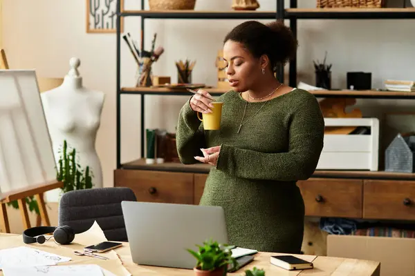 A beautiful woman enjoys a warm beverage while engaging in crafting activities at her workshop. — Stock Photo