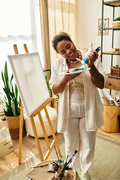 Uma bela mulher gosta de pintar em uma oficina de artesanato bem iluminada repleta de vegetação. — Fotografia de Stock