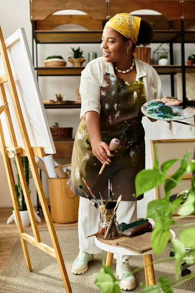 A joyful woman crafts in a bright workspace, surrounded by artistic tools. — Stock Photo