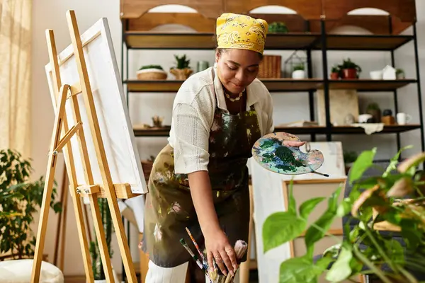 A skilled woman engages in crafting at a lively workshop, surrounded by greenery and art supplies. — Stock Photo