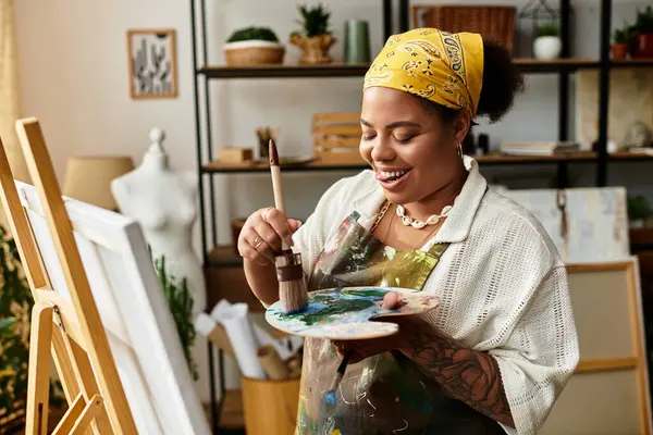 Una hermosa mujer pinta alegremente en un vibrante taller de artesanía, rodeado de suministros. - foto de stock