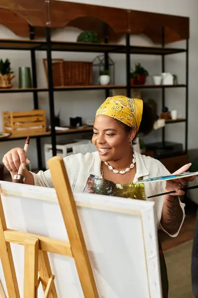 Una mujer talentosa pinta una obra maestra vibrante en un taller animado. - foto de stock