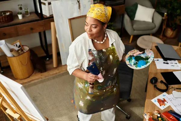 Un hábil artesano se involucra alegremente con colores y materiales en un animado taller de artesanía. - foto de stock
