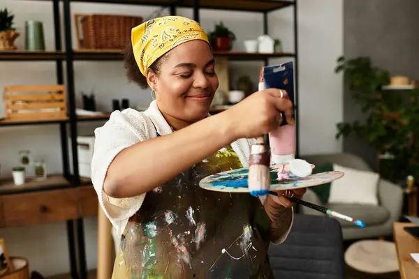 A joyful woman paints at a lively crafting workshop full of creativity. — Stock Photo