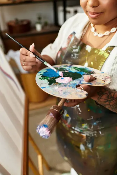 A talented woman expresses her artistic flair as she paints in a colorful crafting workshop setting. — Stock Photo