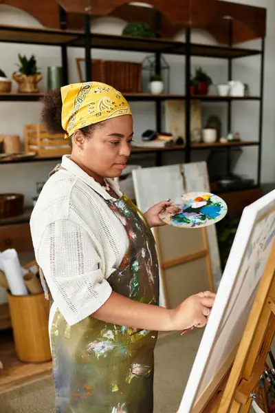 Una donna esperta si esprime attraverso la pittura in un vibrante laboratorio artigianale. — Foto stock