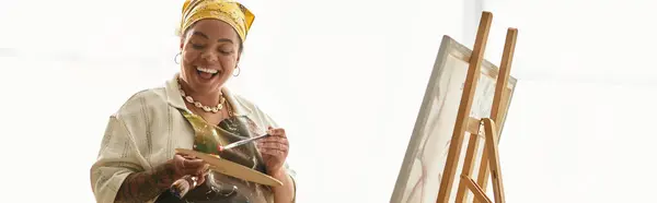 Mujer alegre se involucra en obras de arte, mostrando su talento y creatividad en un animado espacio de elaboración. - foto de stock