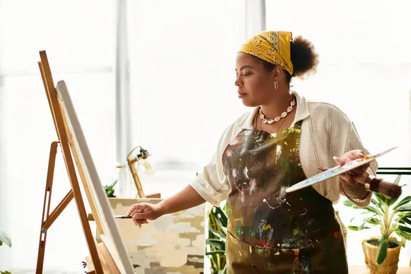 Una hermosa mujer se sumerge en la elaboración de un taller animado, rodeado de materiales de arte. - foto de stock