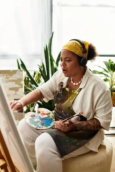 Una bella donna crea con passione arte in un laboratorio artigianale immerso nel verde. — Foto stock