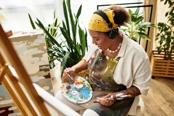 A beautiful woman enjoys creating art during a lively crafting session in a bright workshop. — Stock Photo