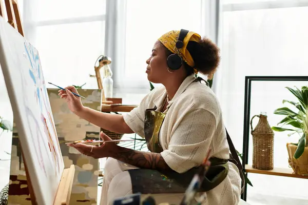 A skilled woman paints, immersed in a vibrant, inspiring crafting atmosphere. — Stock Photo
