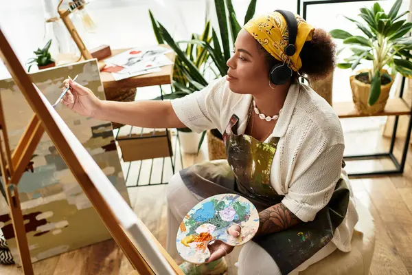 A beautiful woman explores her creativity in an inspiring, vibrant workshop. — Stock Photo