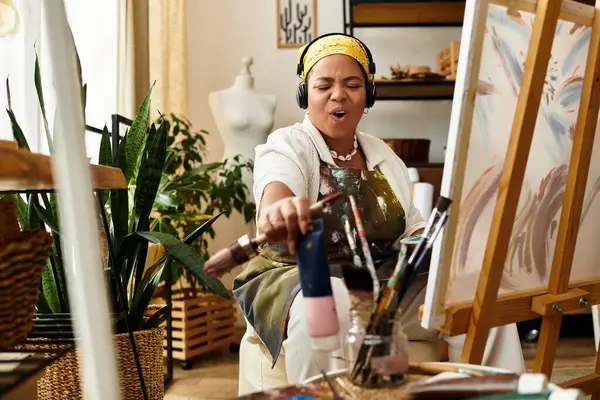 A beautiful woman immersed in her crafting workshop, enjoying the joy of artistic creation. — Stock Photo