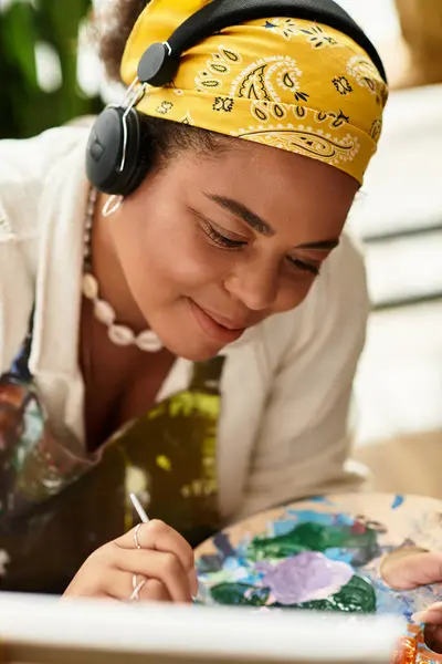 Una mujer hermosa da vida a su creatividad en un animado taller de artesanía mientras pinta. - foto de stock