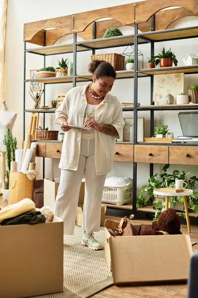Hermosa mujer se dedica a la elaboración rodeada de cajas y decoración rústica en un animado taller - foto de stock