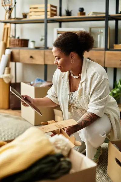 Una mujer hermosa se dedica a un taller de artesanía, explorando meticulosamente sus materiales creativos. - foto de stock