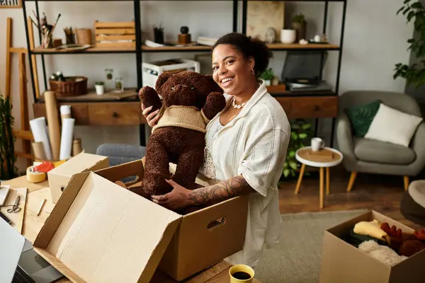 Una bella donna lavora gioiosamente in un laboratorio artigianale, circondata da forniture e creatività. — Foto stock