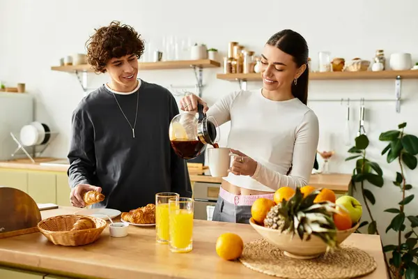 A couple enjoys breakfast together, pouring coffee and savoring pastries in their cozy kitchen. — Stock Photo