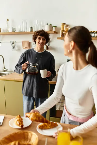 Casal desfrutando de um delicioso café da manhã juntos, com sorrisos e risos em sua cozinha convidativa. — Fotografia de Stock
