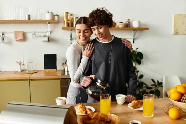 Un couple partage le petit déjeuner et le café dans leur cuisine lumineuse, embrassant chaleureusement. — Photo de stock