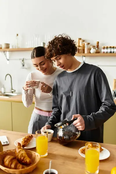 A sweet couple enjoys a Sunday morning at home preparing breakfast and sipping coffee. — Stock Photo