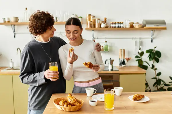 Dois parceiros se deleitam com a companhia um do outro enquanto desfrutam de doces e bebidas em sua casa. — Fotografia de Stock