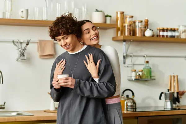 A joyful couple shares a tender moment in their bright kitchen, enjoying each others company. — Stock Photo