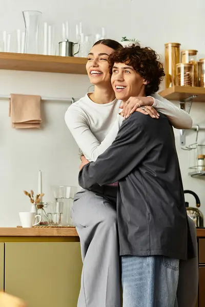 Loving couple shares a warm embrace at home, enjoying their cozy kitchen ambiance together. — Stock Photo
