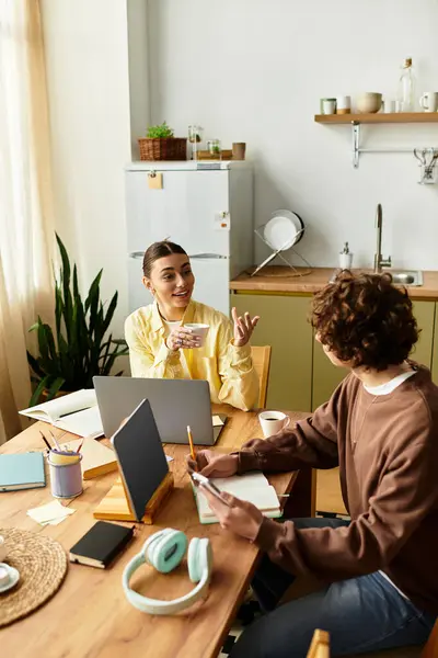 Loving couple shares laughter and conversation while working on their projects in a warm kitchen. — Stock Photo