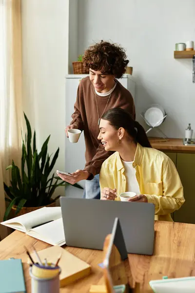 Paar genießt Gesellschaft bei Kaffee, während es zu Hause an einem gemeinsamen Projekt arbeitet. — Stockfoto
