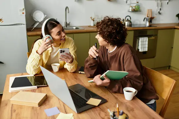 Dois indivíduos compartilham riso e conexão enquanto se envolvem em atividades de trabalho em casa. — Fotografia de Stock