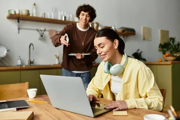 Loving couple enjoys each others company as one focuses on work while the other brings a treat. — Stock Photo