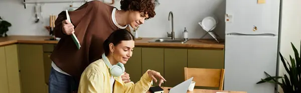 Man and woman share laughter and ideas while collaborating on a laptop at their kitchen table. — Stock Photo