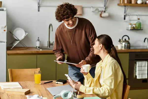 Um casal compartilha um momento quente em sua mesa de cozinha, banhado na luz da manhã. — Fotografia de Stock