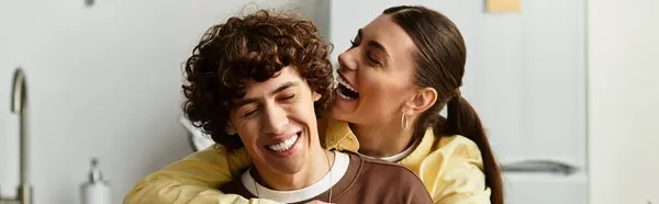 A joyful couple shares laughter in their cozy home during a peaceful afternoon, embracing love. — Stock Photo