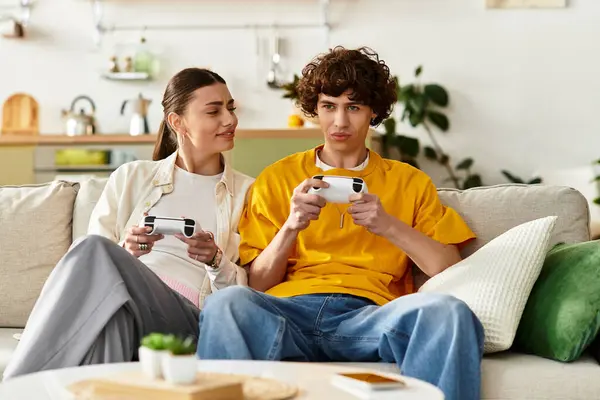 Loving pair share a joyful moment gaming together on a comfortable couch in their stylish home. — Stock Photo