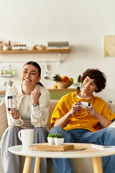 A couple shares smiles and fun while gaming on a cozy couch in their inviting living room. — Stock Photo