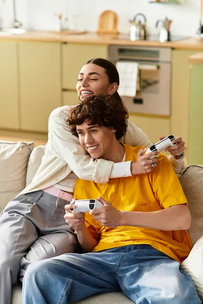 Casal desfruta de uma noite divertida juntos, jogando videogames no sofá e compartilhando momentos alegres. — Fotografia de Stock