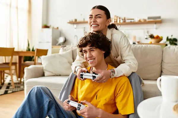 A couple enjoys a playful gaming session at home, laughing and sharing their joy together. — Stock Photo