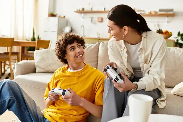 A man and woman share laughter as they play video games on the couch in their stylish home. — Stock Photo