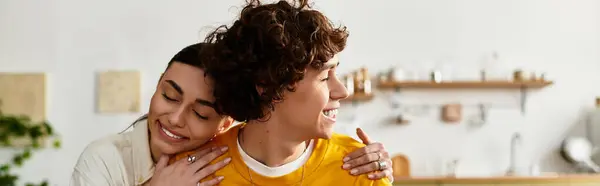Ein Mann und eine Frau umarmen sich liebevoll in einer warmen und einladenden Küche und strahlen Glück aus. — Stockfoto