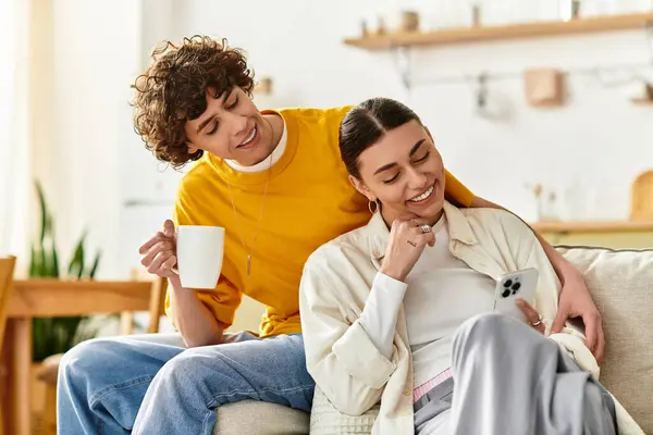 Zwei Menschen teilen eine fröhliche Interaktion auf einer bequemen Couch zu Hause und umarmen die Liebe. — Stockfoto